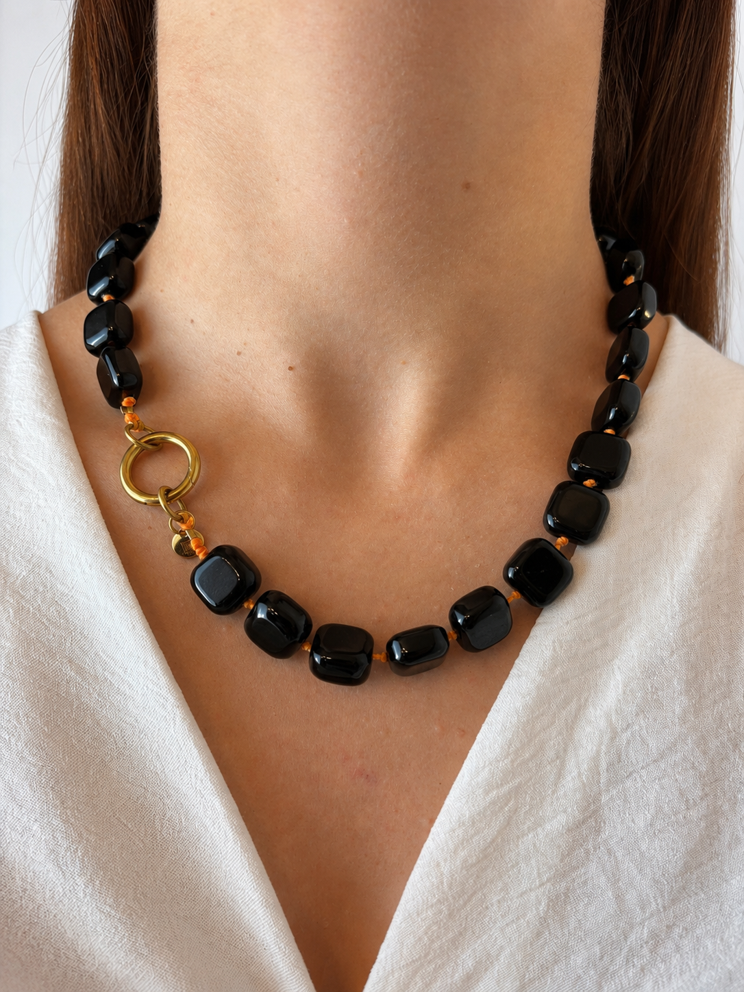 Collar Arun — Cuadrado Negro y cordón flúor naranja.